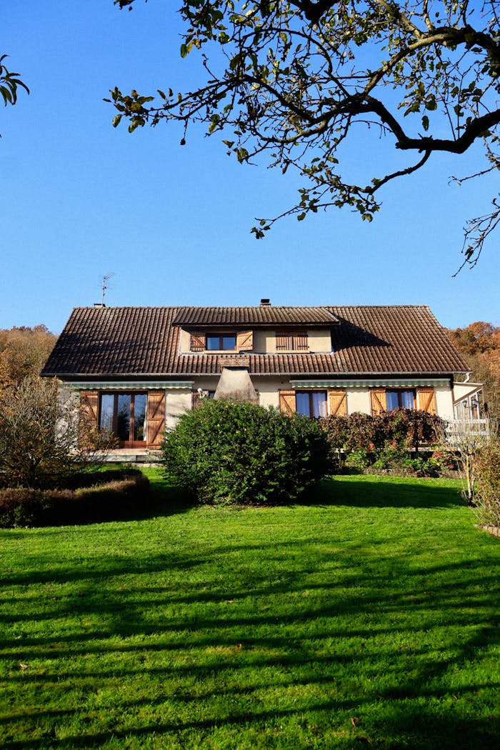 Peaceful country house with a lush garden under a clear blue sky